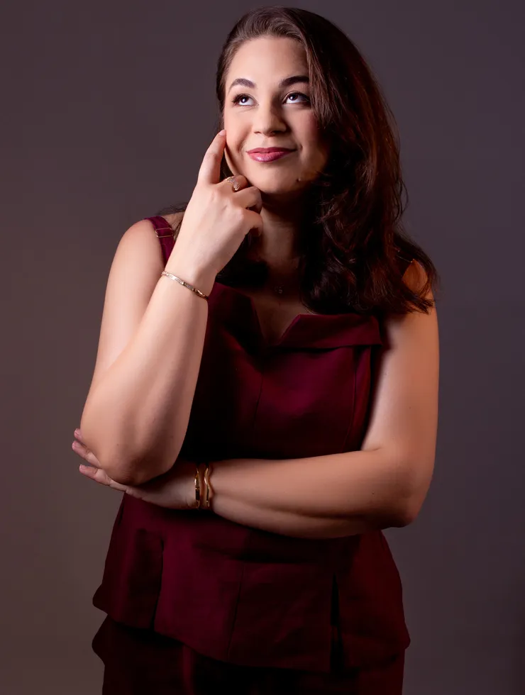 Rebeca Marinho em pé, usando blazer azul-marinho, em retrato profissional